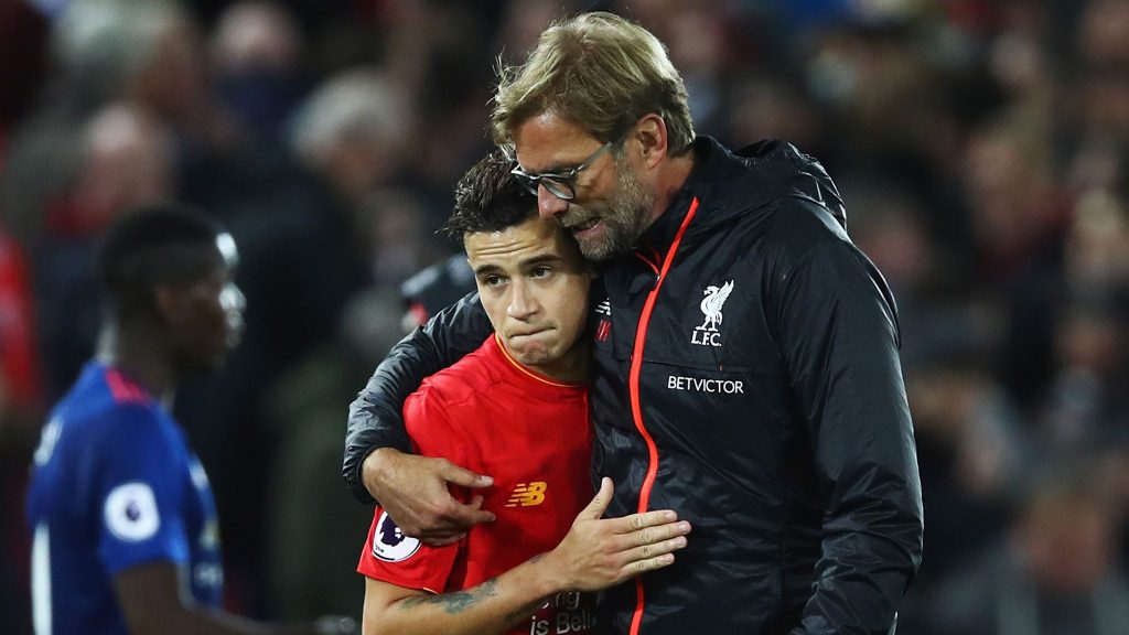 Philipe Coutinho and Jurgen Klopp hugging after a Liverpool match