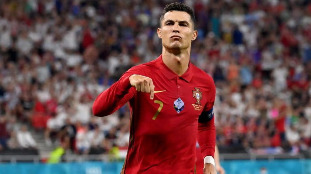 Cristiano Ronaldo in a Portugal shirt, pointing to the ground celebration