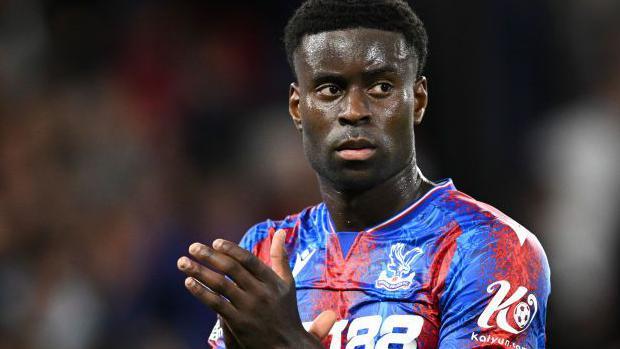 Marc Guehi clapping in a Crystal Palace shirt