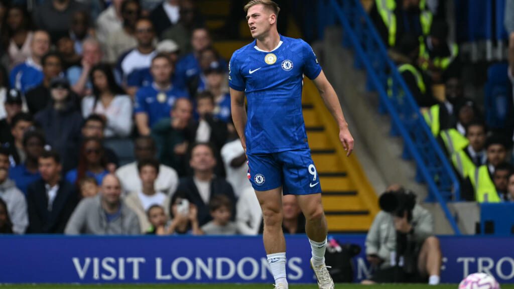 Liam Delap holding his hamstring while playing for Chelsea