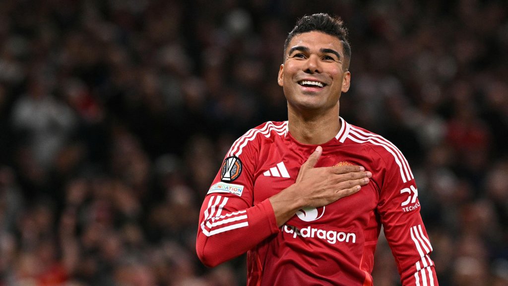 Casemiro with his hand on the Manchester United badge