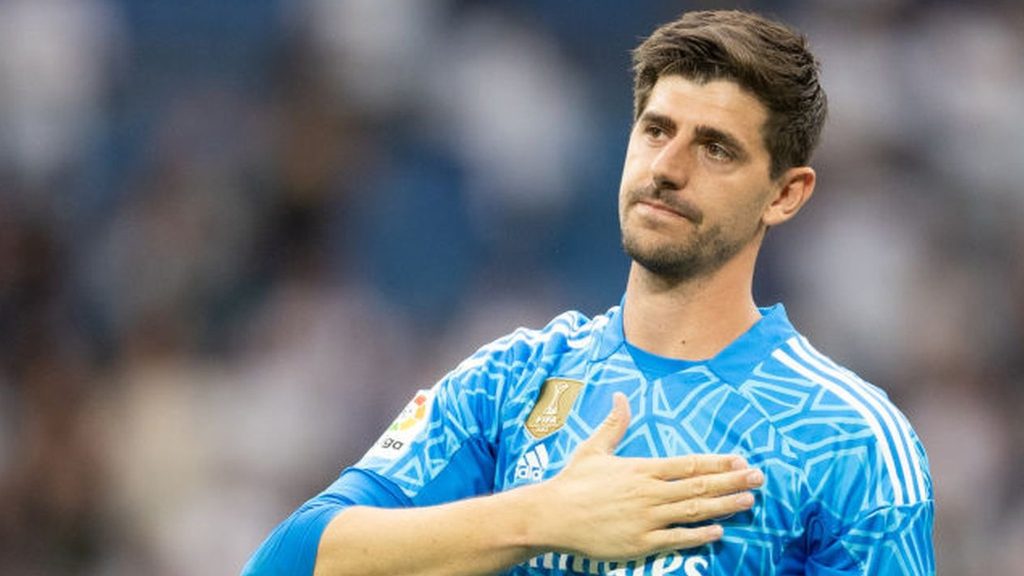 Thibaut Courtois patting the Real Madrid logo on his shirt