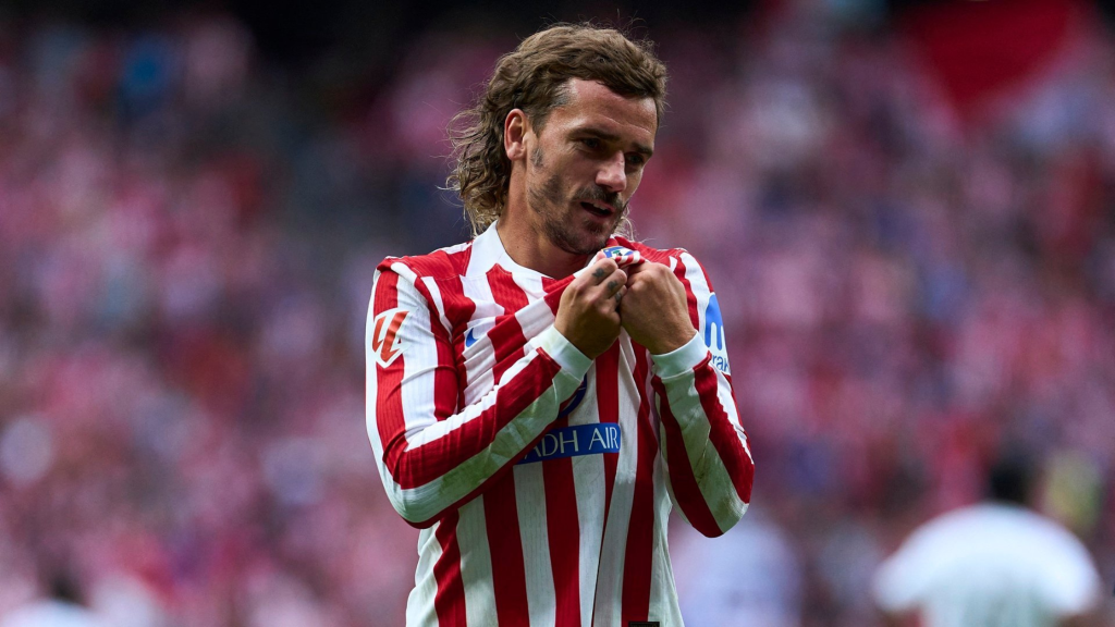 Frontview of Antoine Griezmann pointing to the Atletico Madrid badge