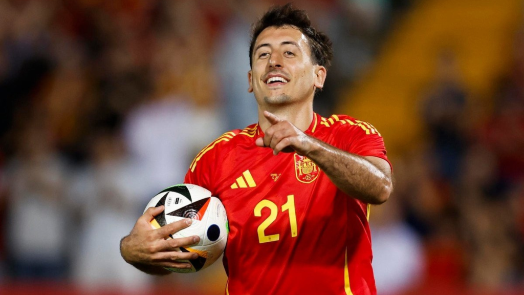 Frontview of Mikel Oyarzabal holding the ball and pointing his finger while playing for Spain