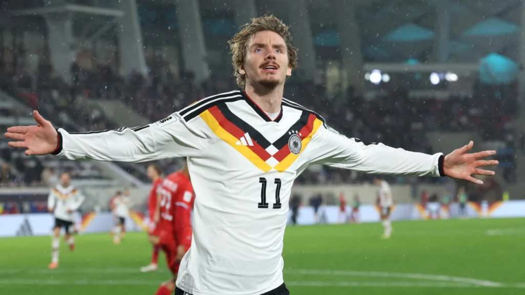 Frontview of Nick Woltemade with his arms wide in celebration while playing for Germany