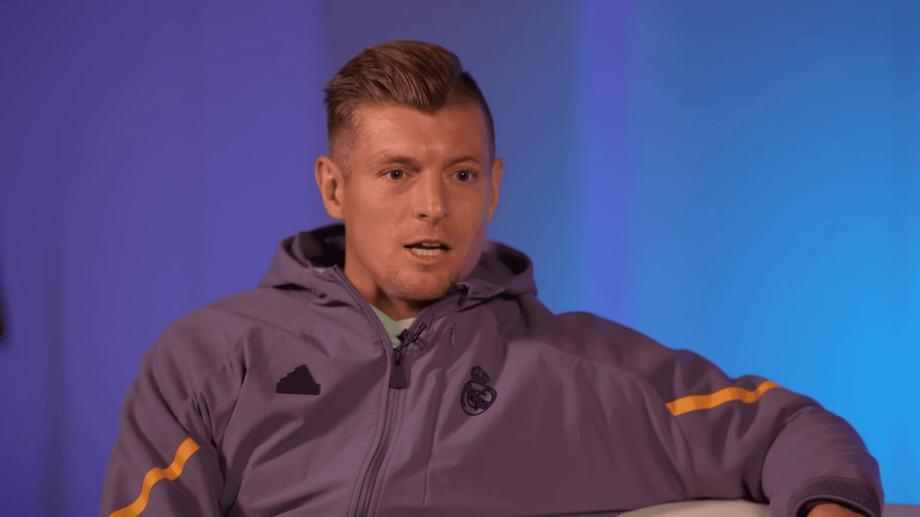 Frontview of Toni Kroos speaking while wearing a Real Madrid jacket