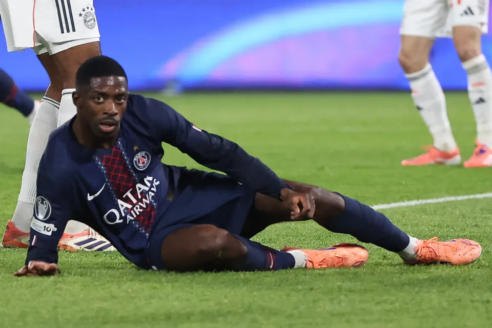 Sideview of Ousmane Dembele laying on the pitch injured for PSG
