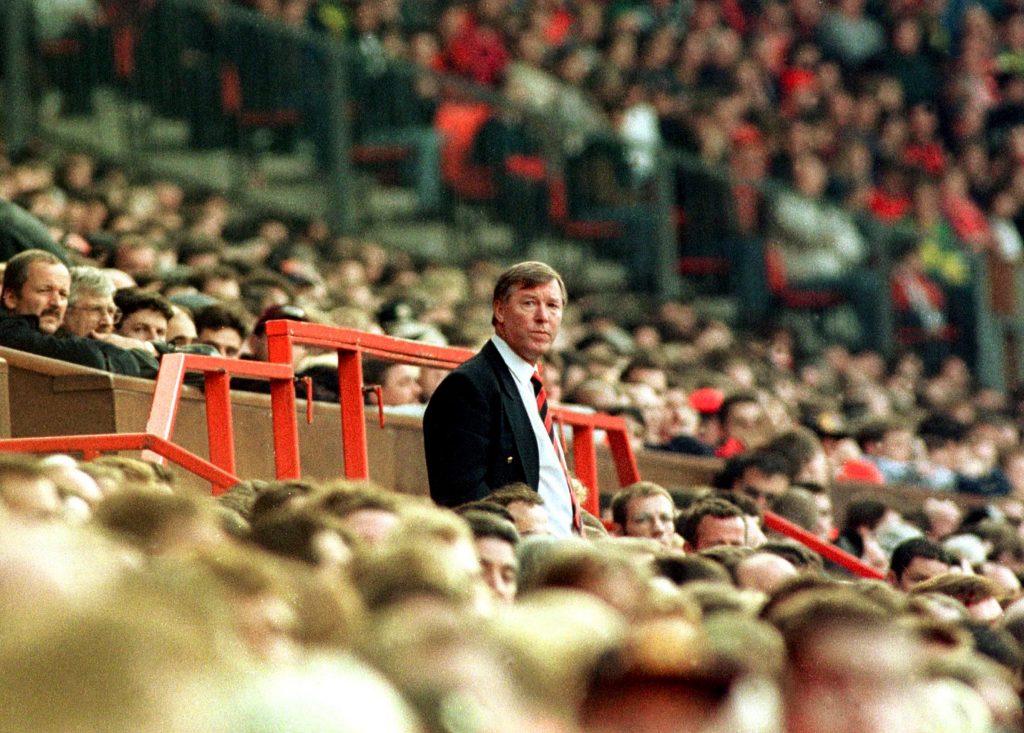 Sir Alex Ferguson standing among the Manchester United fans