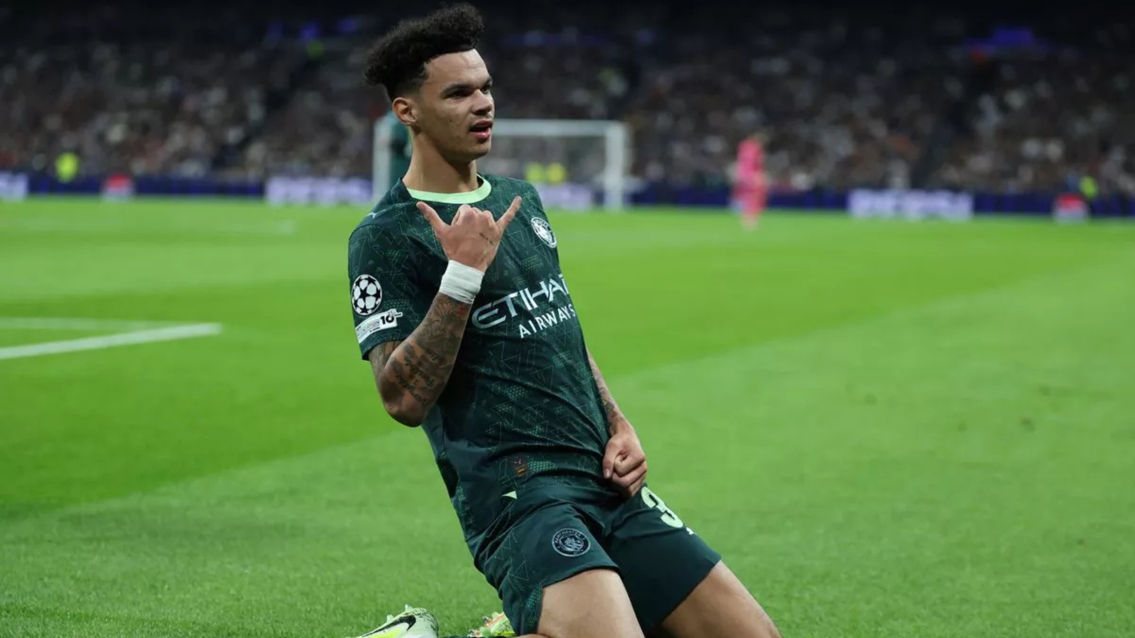 Sideview of Nico o Reilly doing a knee slide for Manchester City at the Bernabeu after scoring