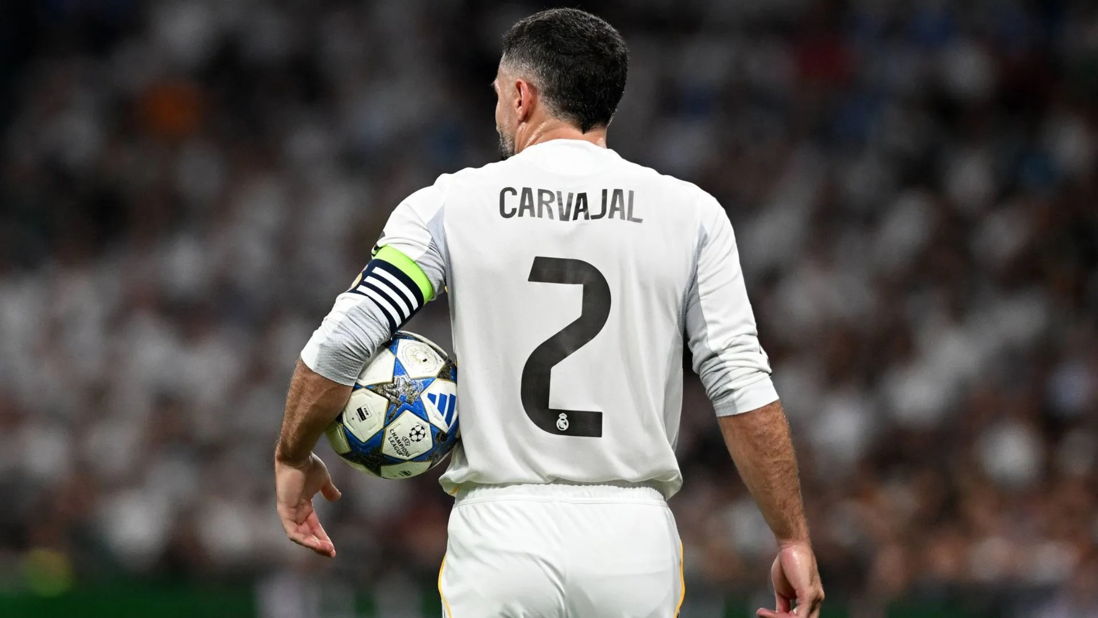 Backview of Dani Carvajal holding the ball under his arm and playing for Real Madrid